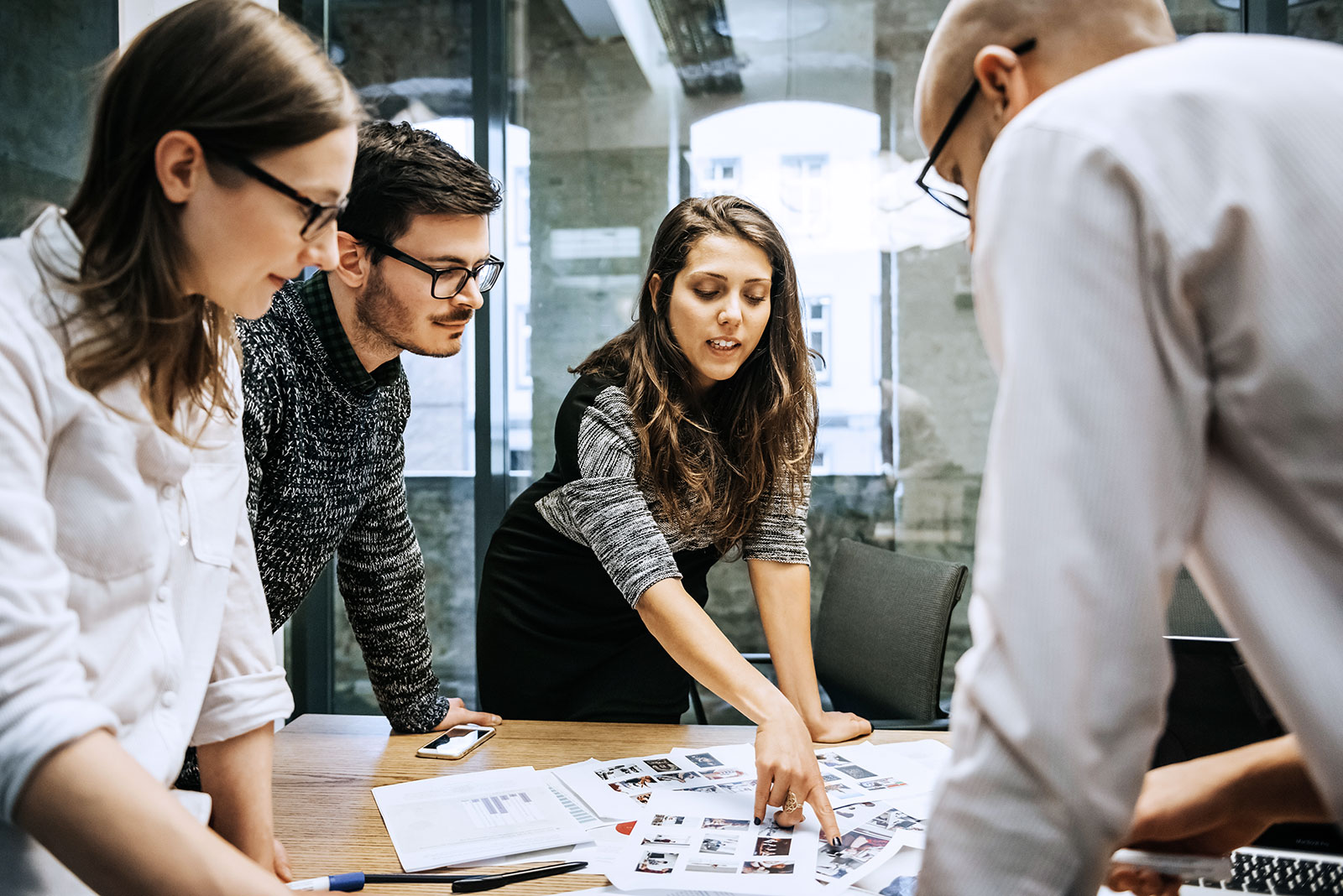 Ein Team von Mitarbeitern tauscht sich am Konferenztisch über Ideen aus: Teamwork so, wie es bisher war – aber durch die Digitalisierung in vielen Bereichen nicht mehr lange sein wird.