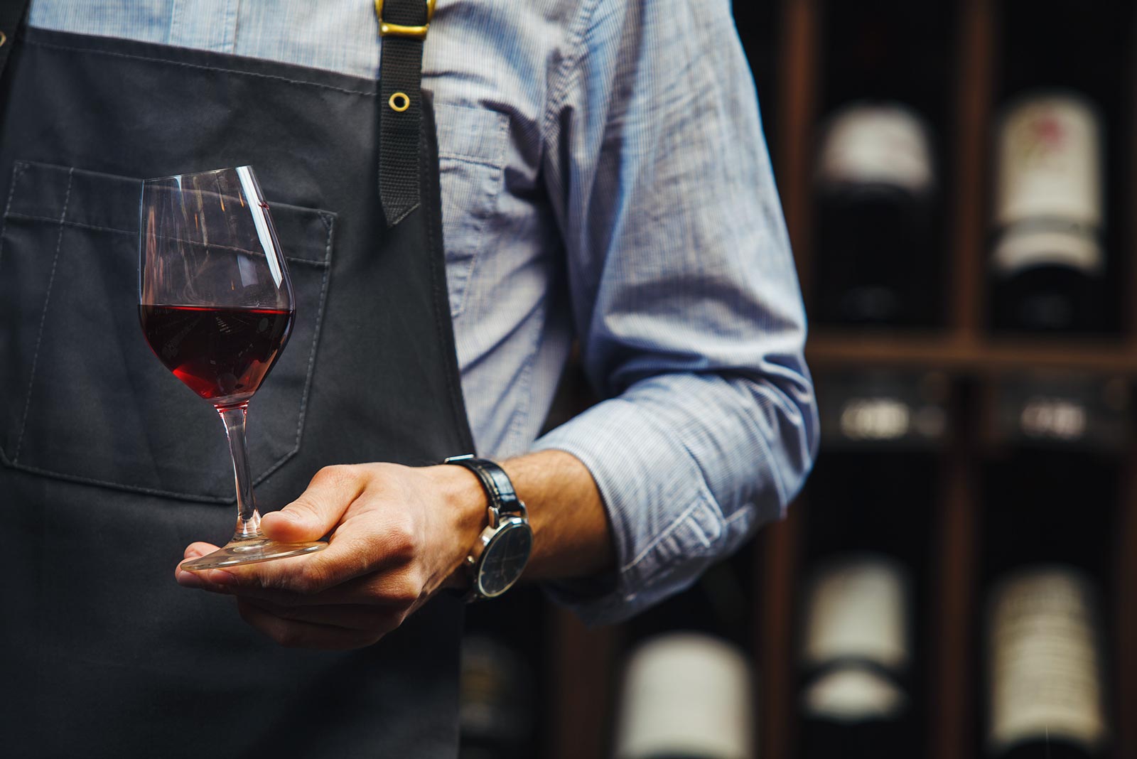 Ein Mann mit einem Glas Rotwein in der Hand