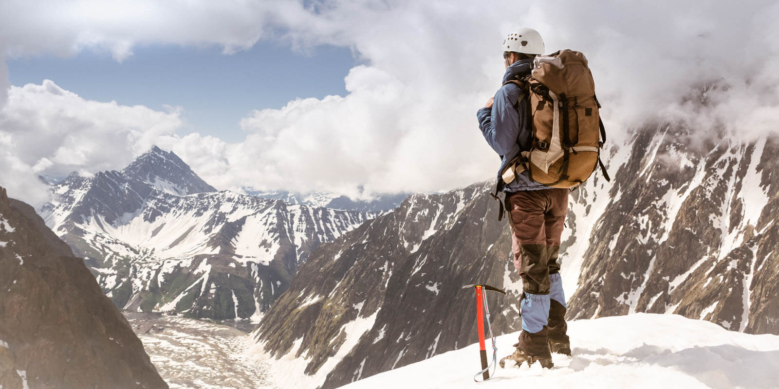 Ein Bergsteiger steht auf einem Berg und schaut in die Ferne