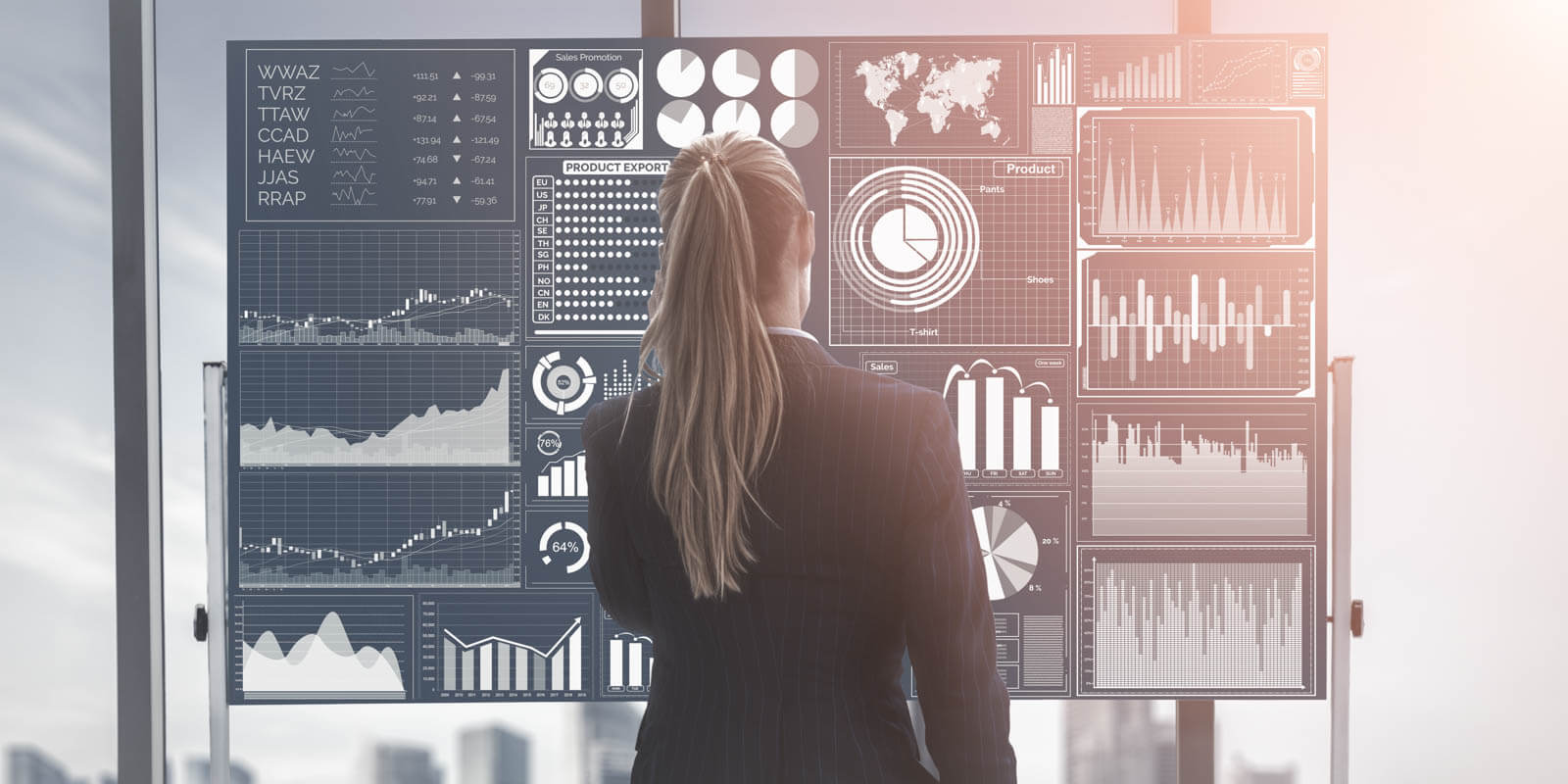 Eine Frau steht vor einer Wand mit Diagrammen und Charts um Daten zu analysieren